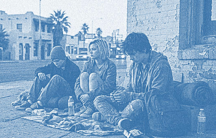 Three teenagers sitting on corner of street
